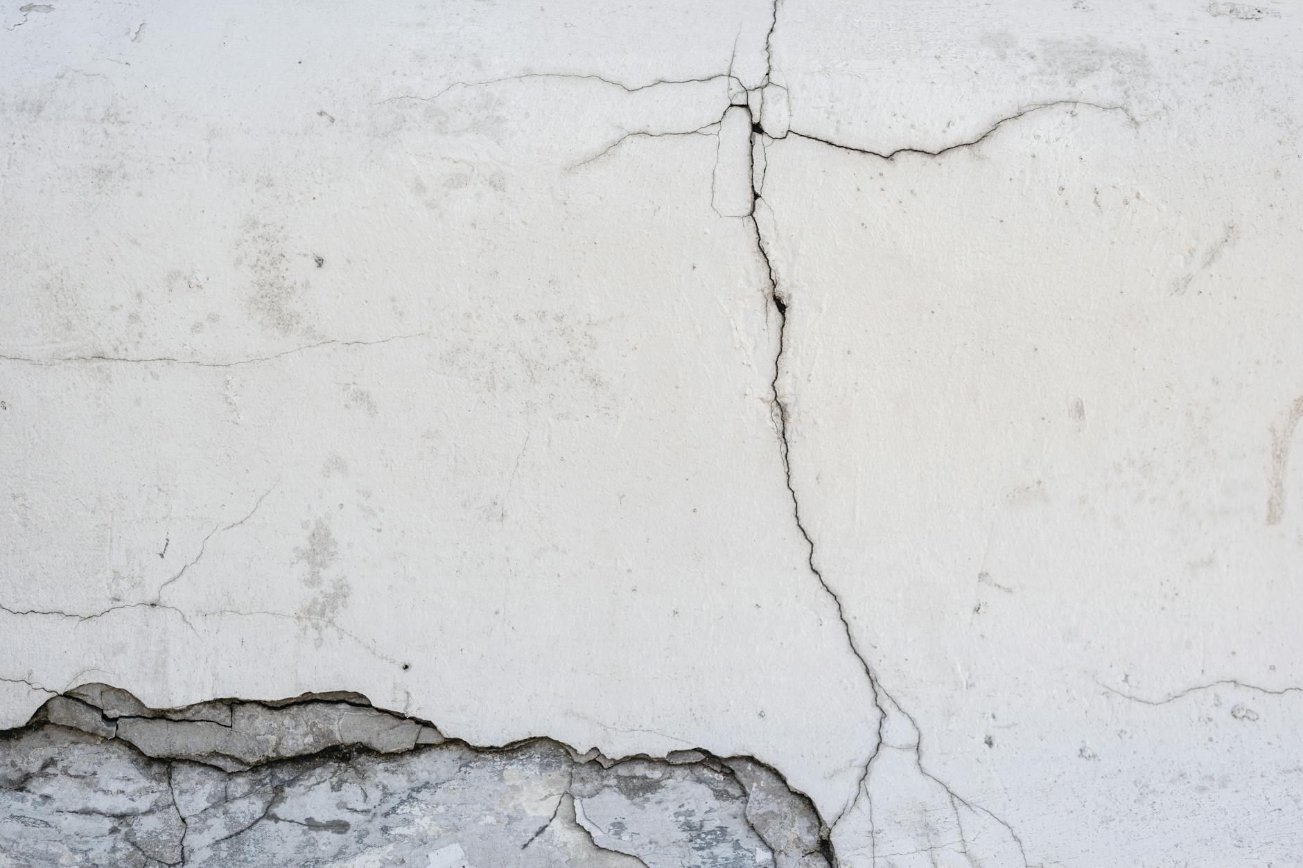 close up photo of a white wall with cracks
