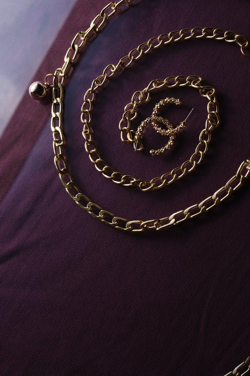 elegant gold chain on dark fabric background